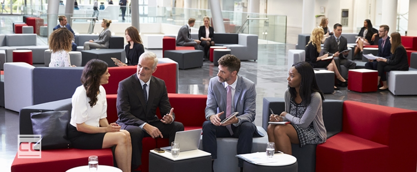business people sitting in corporate building lobby on fabric office furniture