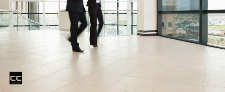 people walking on tile in a corporate building