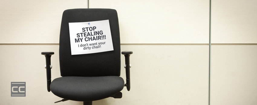 Office chair with sign that says "Stop stealing my chair. I don't want your dirty chair."