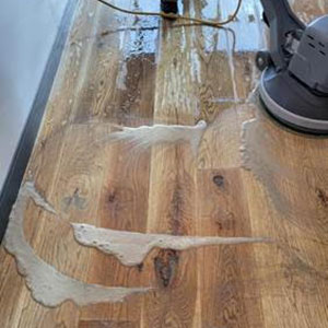 Deep cleaning scrub of wood flooring before applying a protective coating.
